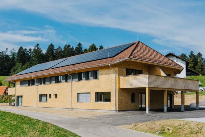 Außenansicht Tagespflege mit Schindelfassade und Photovoltaikanlage auf dem Dach.
